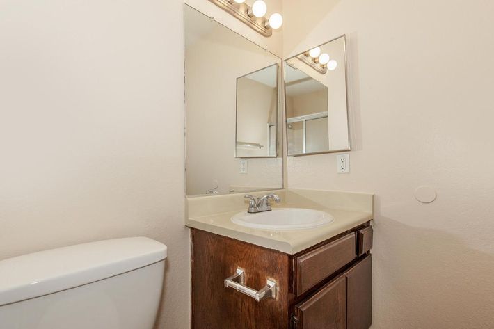 a white sink sitting under a mirror