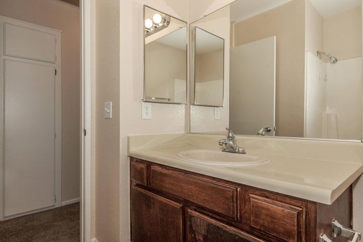 a white sink sitting under a mirror next to a shower