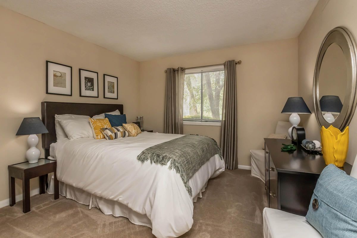 a bedroom with a bed and desk in a hotel room