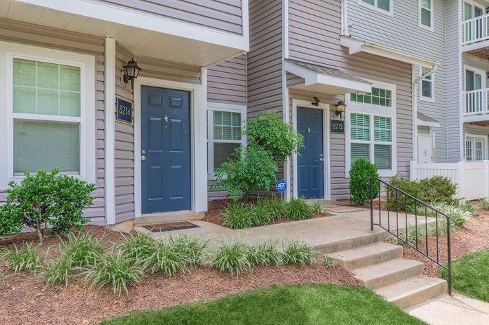 a house with bushes in front of a building