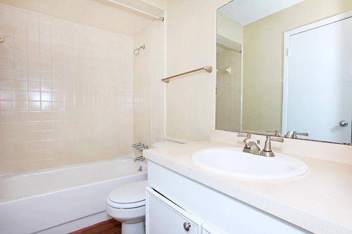 a white sink sitting under a mirror