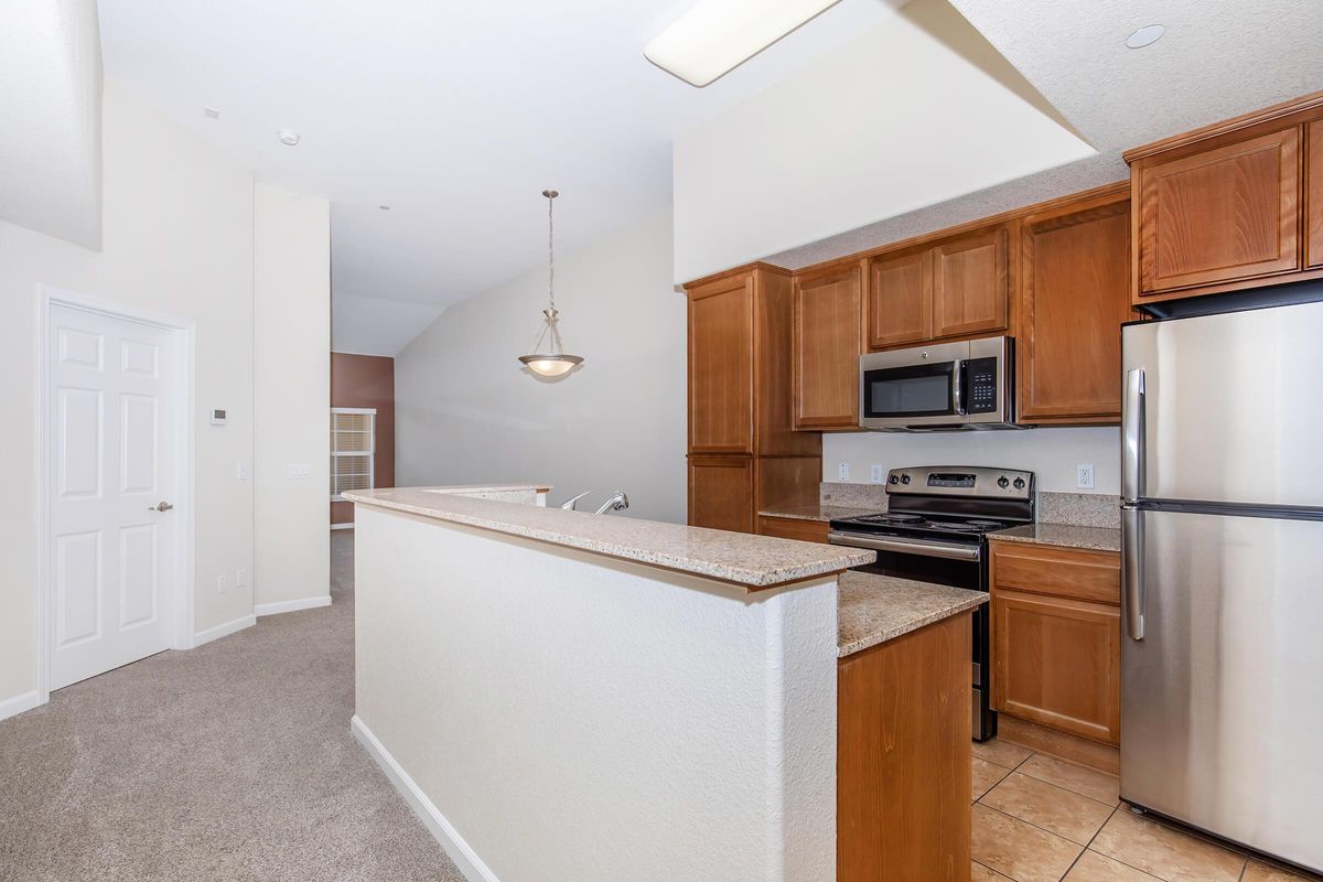 a large kitchen with stainless steel appliances and wooden cabinets