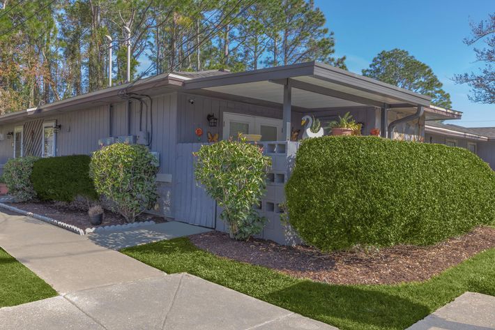 a large brick building with grass in front of a house