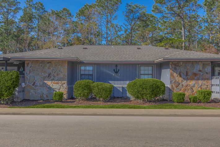 a house that has a sign on the side of a road