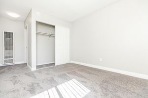 carpeted bedroom with sliding closet doors