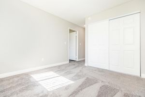 carpeted bedroom with closed closet doors