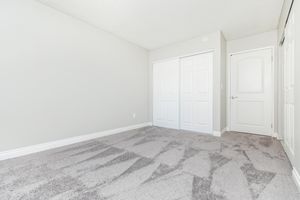 vacant carpeted bedroom with closed closet doors