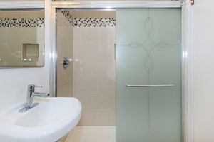 a white sink sitting under a mirror