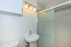 a white sink sitting under a mirror