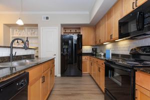 a modern kitchen with stainless steel appliances and wooden cabinets