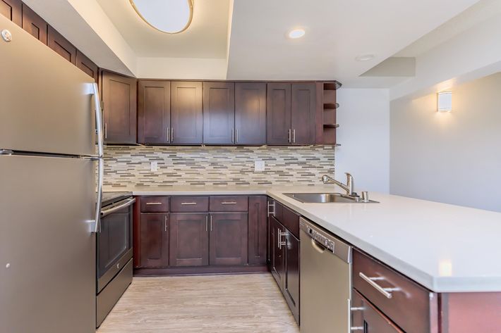 a large kitchen with stainless steel appliances and wooden cabinets