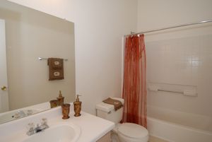 a white sink sitting under a mirror