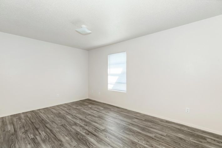 a bedroom with a wooden floor