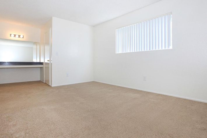 Carpeted bedroom with vanity