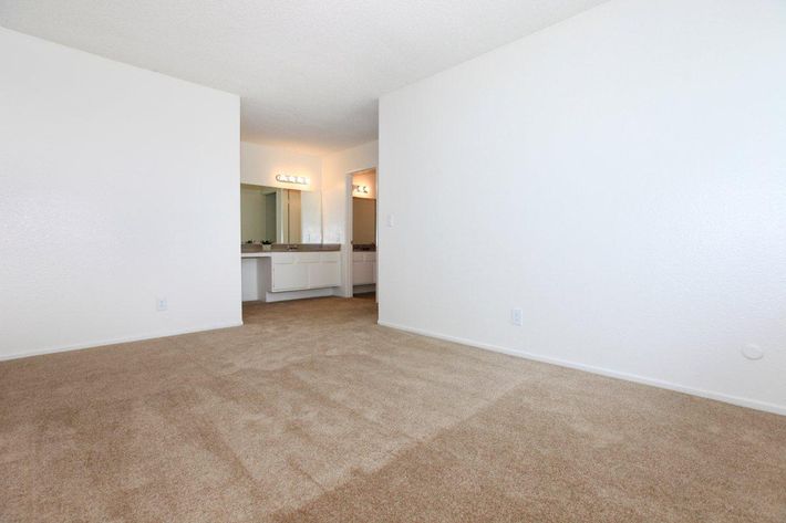 Carpeted bedroom with bathroom sink