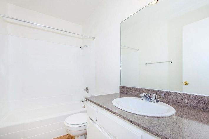 Vacant bathroom with white cabinets