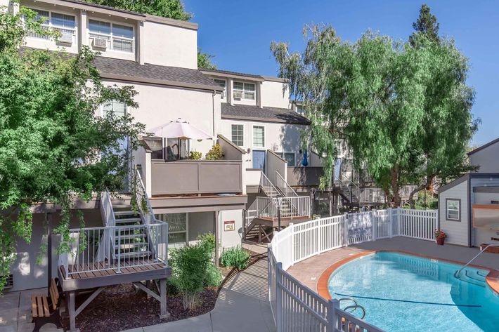 a building with a fence in front of a pool