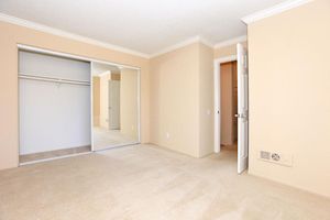 Unfurnished bedroom with open sliding mirror glass closet doors