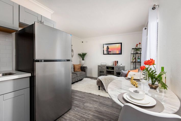 a kitchen with a refrigerator and a table in a room