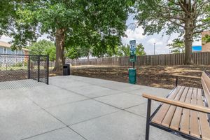 an empty park bench next to a fence