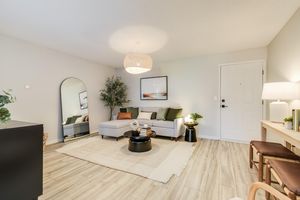 Front door and spacious living room interior including furniture at The Arbor, in Blue Springs, MO