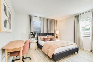 Bed and desk inside platinum bedroom interior at The Arbor in Blue Springs, Missouri