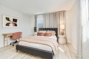 Bed and desk inside platinum bedroom interior at The Arbor in Blue Springs, Missouri