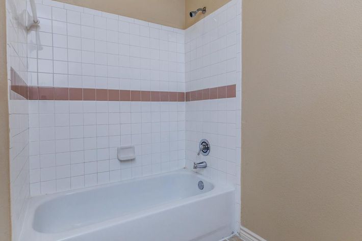a white sink sitting next to a tiled wall