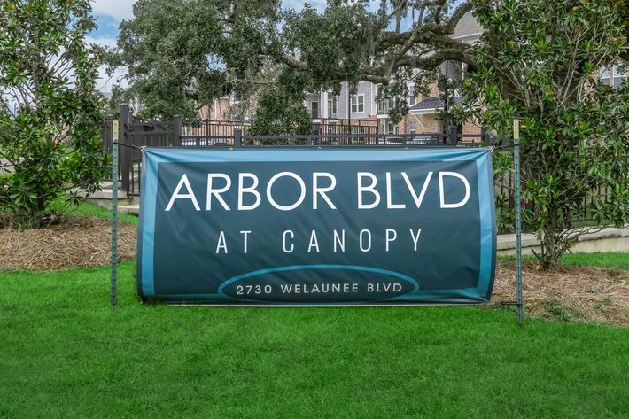 a blue sign in front of a green field