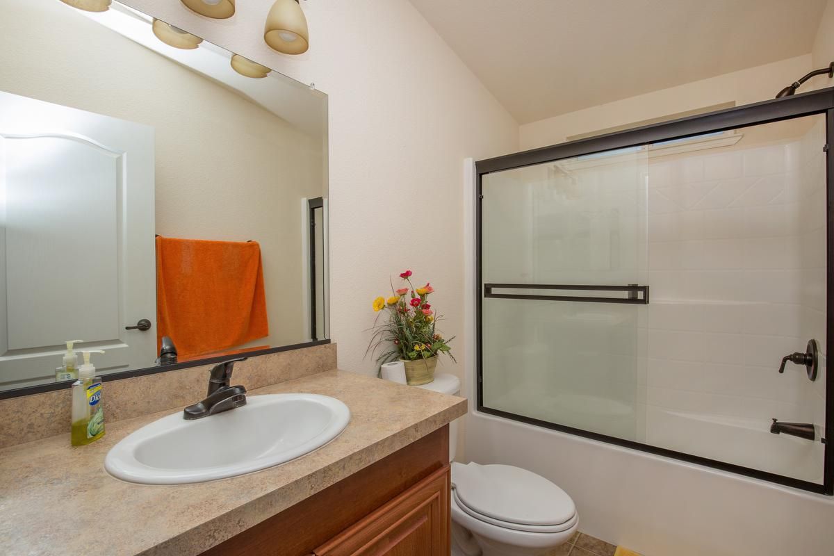 a white sink sitting under a mirror