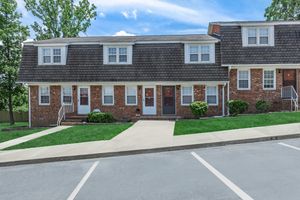 a large brick building with grass in front of a house