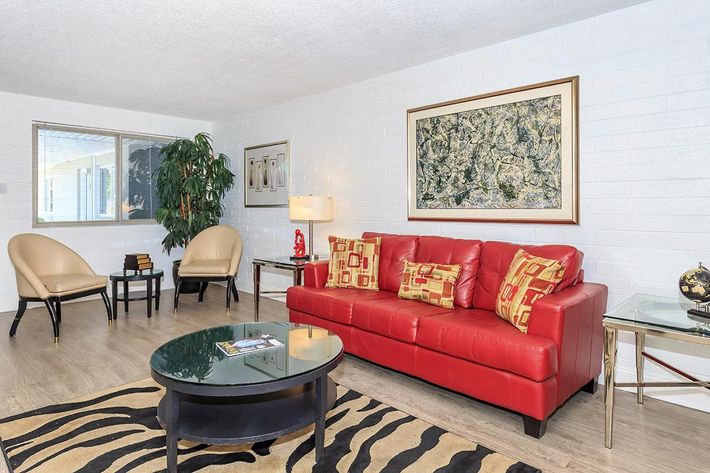 a living room filled with furniture and a red rug