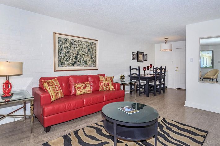 a living room filled with furniture and a red rug