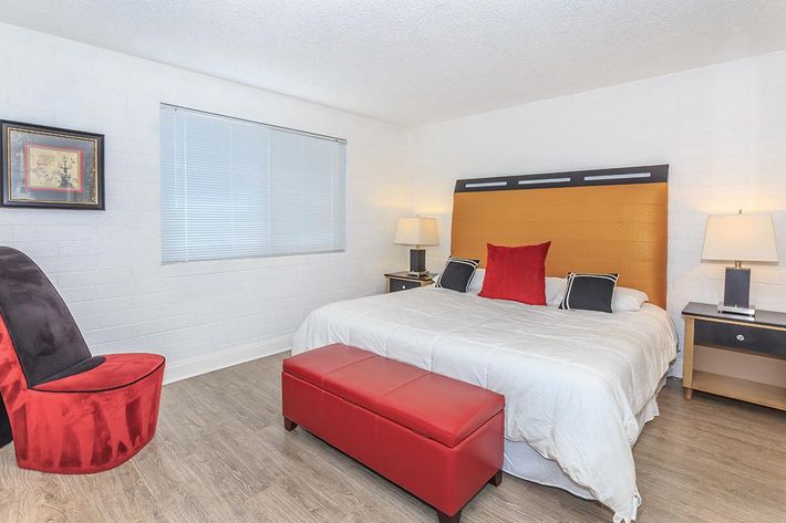 a bedroom with a bed and desk in a hotel room