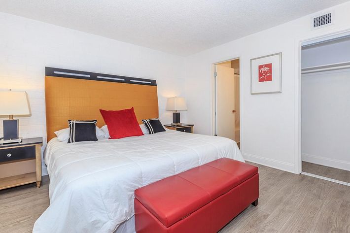 a bedroom with a bed and desk in a room