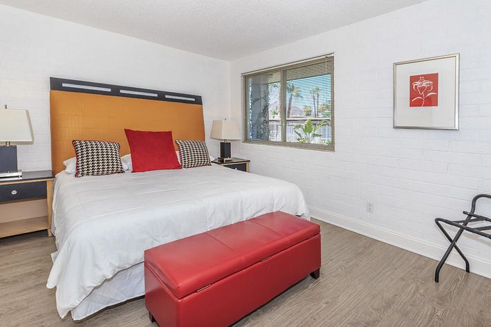 a bedroom with a bed and desk in a room