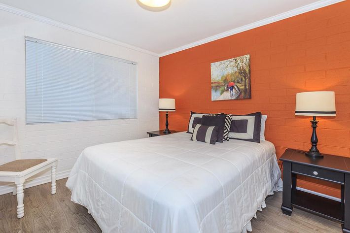 a bedroom with a bed and desk in a hotel room