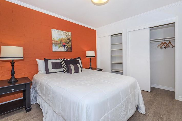 a bedroom with a bed and desk in a room