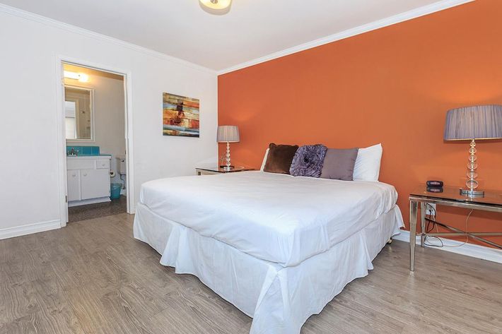 a bedroom with a bed and desk in a room