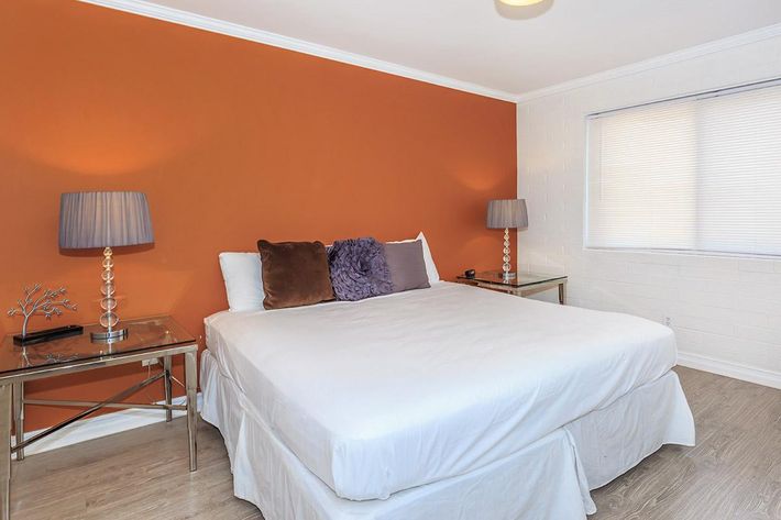 a bedroom with a bed and desk in a hotel room