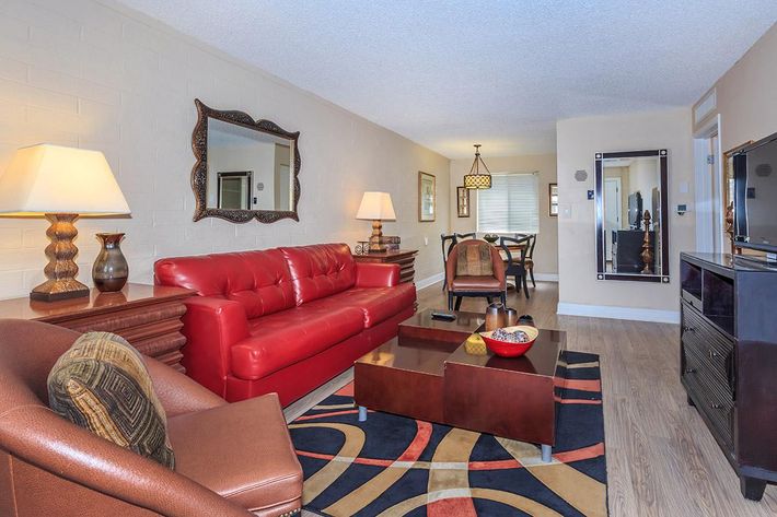 a living room filled with furniture and a red rug