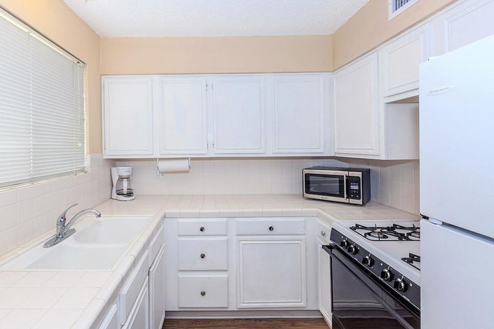 a white stove top oven sitting inside of a kitchen