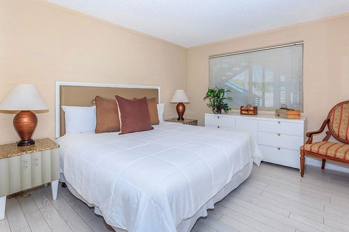 a bedroom with a bed and desk in a room