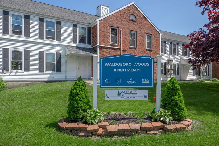 a large brick building with a sign in front of a house