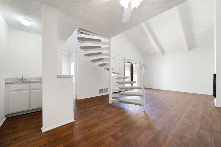 Vacant living room with carpeted stairs