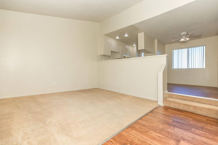 Carpeted living room and steps to dining room