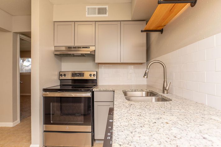 a stove top oven sitting inside of a kitchen