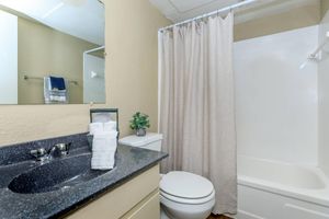 a white sink sitting next to a shower