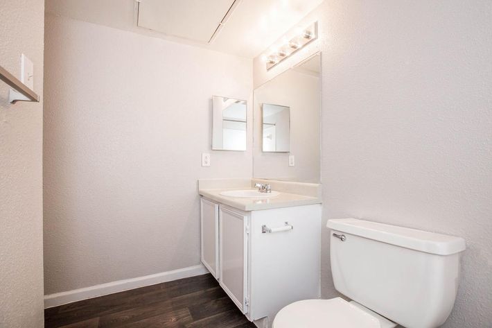 a white sink sitting under a mirror