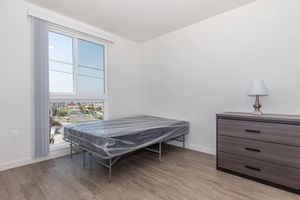 a bedroom with a bed and desk in a room